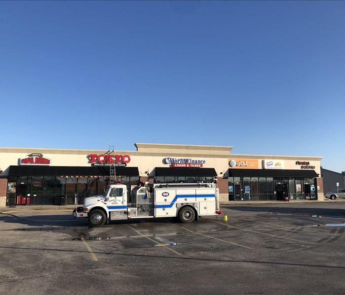 Strip mall with truck in front of the stores 